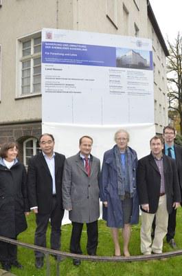 Professoren der Pharmazie vor Bauschild der Augenklinik