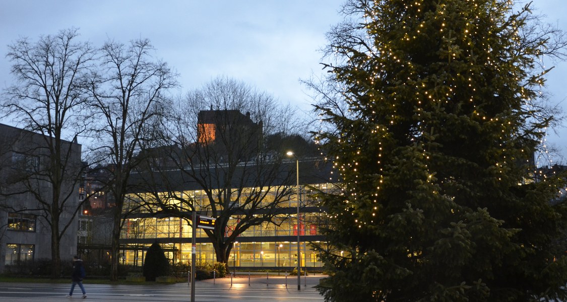 Hörsaalgebäude mit Weihnachtsbaum auf dem Vorplatz der Stadthalle