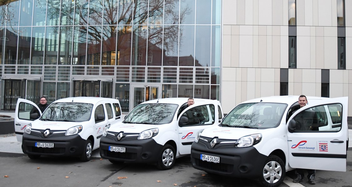 Drei Mitarbeiter des Dezernats Gebäudemanagement und Technik – Christoph Bromm und Markus Reitz (Sicherheitstechnik) sowie Mike Schleich (Stromversorgung) – nehmen die drei Elektroautos der Philipps-Universität in Betrieb.