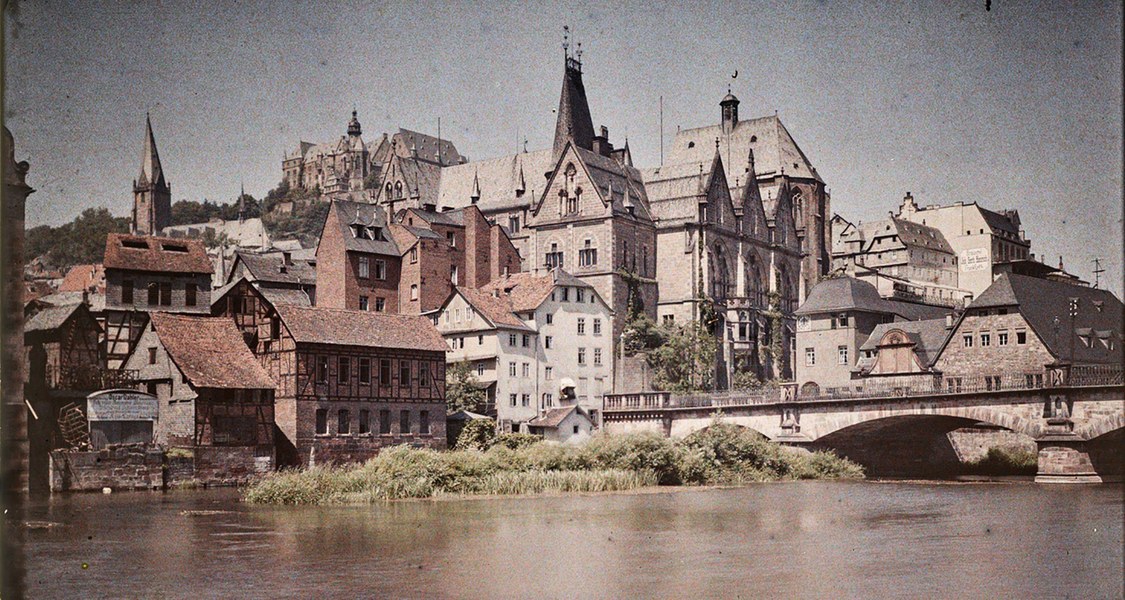 Farbaufnahme mit Blick von Weidenhausen auf die Weidenhäuser Brücke, im Hintergrund die Alte Universität und die Oberstadt mit Schloss um 1910