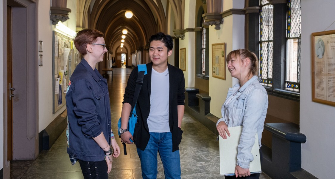 drei Studierende im Flur der Alten Universität