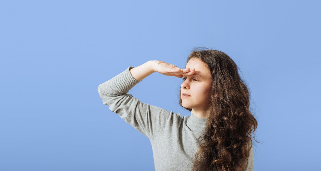 Foto einer Studierenden, die in die Ferne blickt