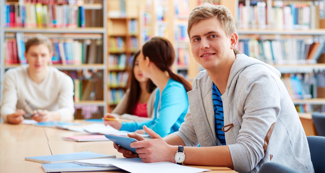 mehrere Personen in einer Bibliothek an einem Tisch