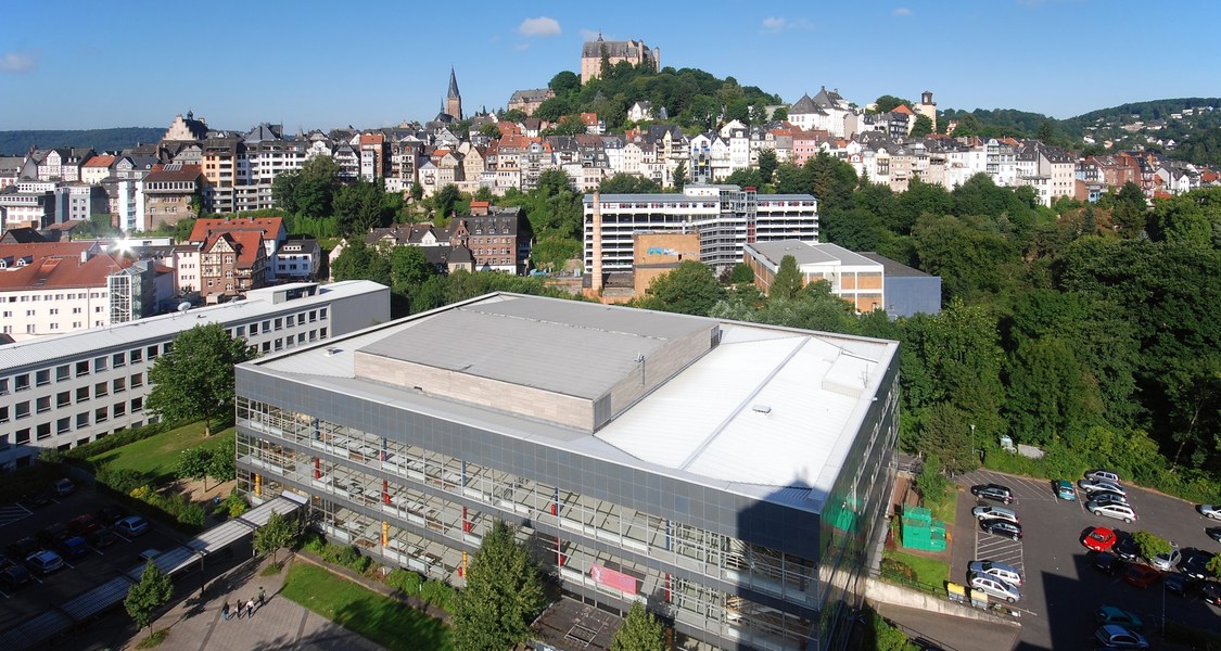 Foto mit Dach des Hörsaalgebäudes und Panorama der Oberstadt im Hintergrund