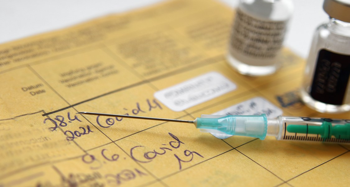 Impfpass mit Spritze und Eintrag von zwei Impfungen mit comirnaty