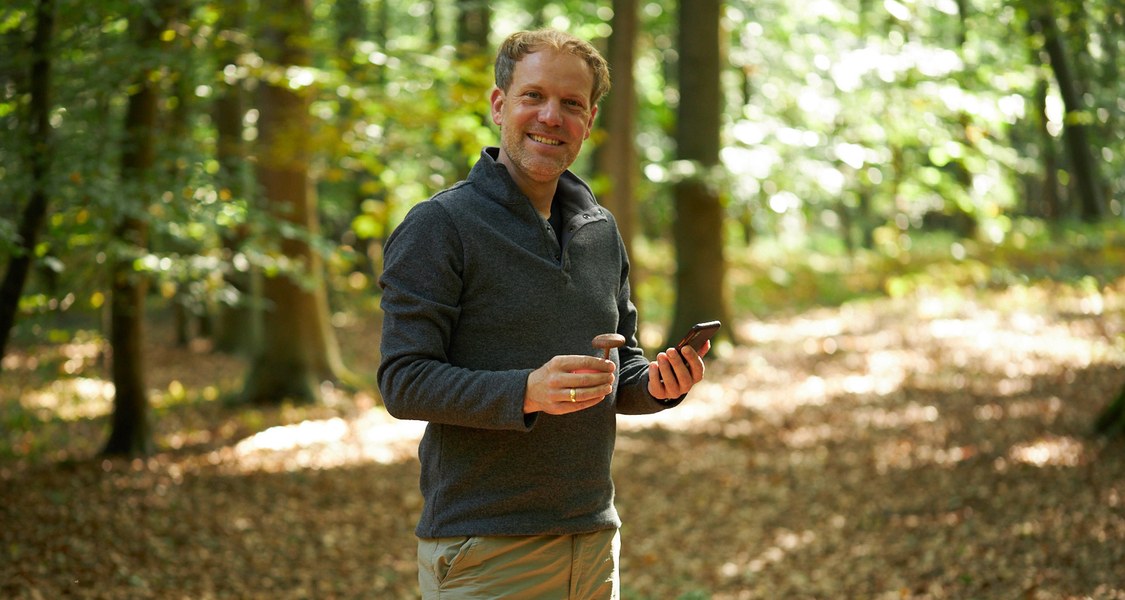 Preisträger mit Mobiltelefon im Wald