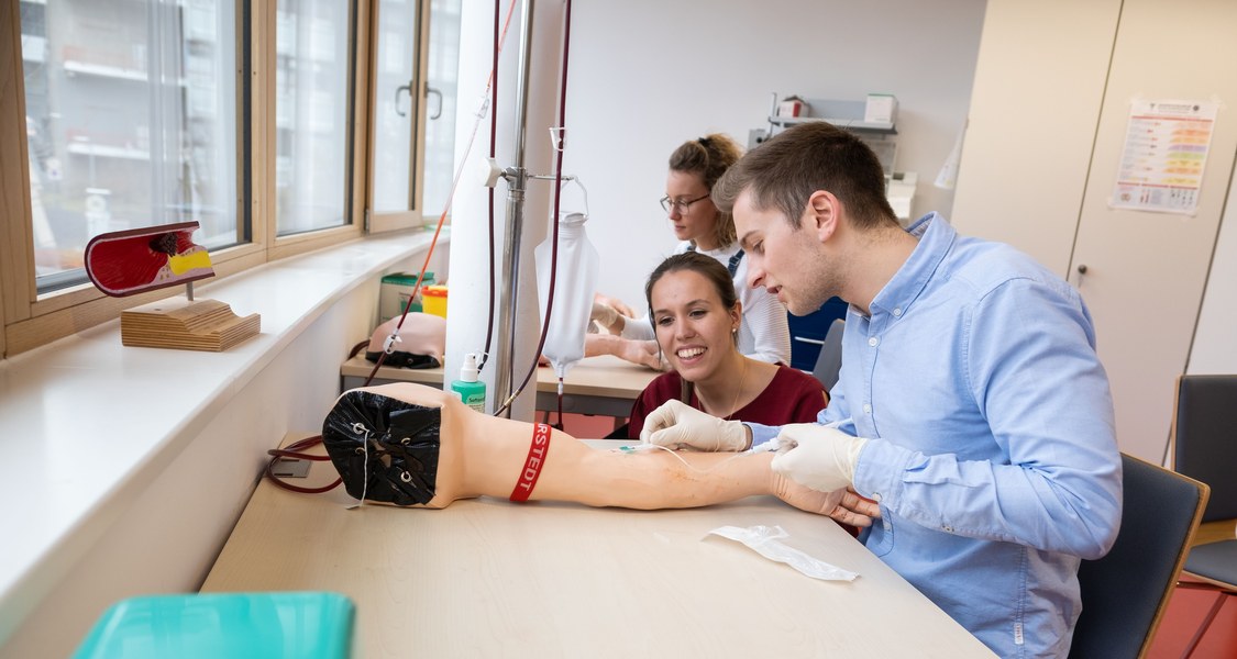 Foto von zwei Medizin-Studierenden bei einer Blutabnahme-Übung