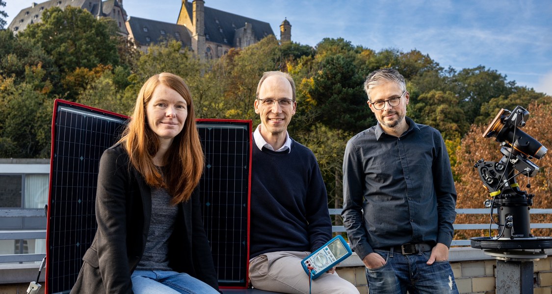 Gruppenfoto Physiker und Physikerinnen auf Dachterrasse mit Photovoltaik-Element