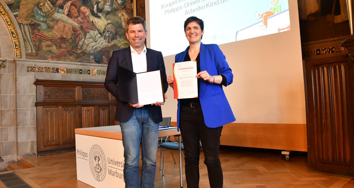 Thomas Nauss, Präsident der Philipps-Universität Marburg (links) und Katja Urbatsch, Gründerin der Initiative ArbeiterKind.de, unterzeichnen einen Kooperationsvertrag in der Alten Aula der Universität.