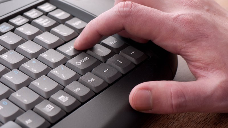 Zeigefinger tippt auf die Enter-Taste einer Computertastatur
