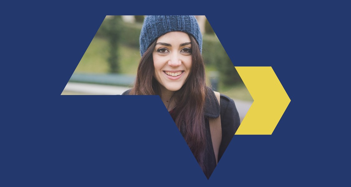 Studentin mit Mütze auf einer blauen Farbfläche mit gelbem Pfeil