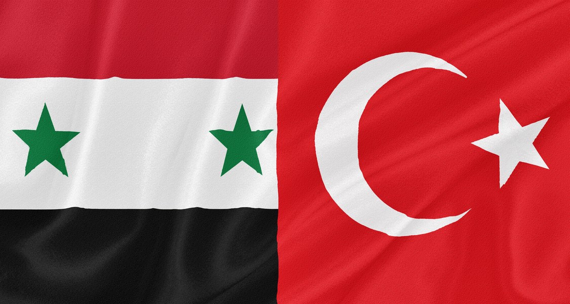 links ein Teil der syrischen Flagge (rot-weiß-schwarz quergestreift (von oben nach unten) mit zwei grünen Sternen im weißen Streifen) und rechts ein Teil der türkischen Flagge (rot mit weißer Mondsichel und weißem Stern)