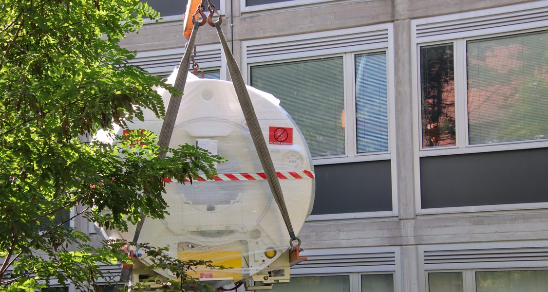 MRT-Gerät wird mit einem Kran in ein Gebäude gehoben