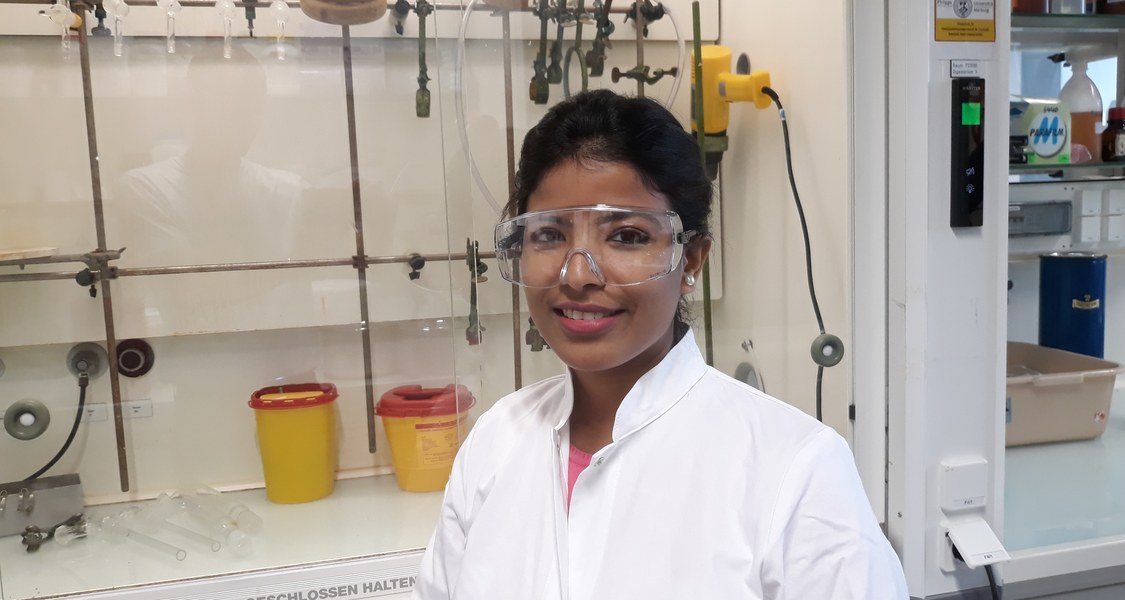 Junge Frau mit Schutzbrille in einem Chemielabor