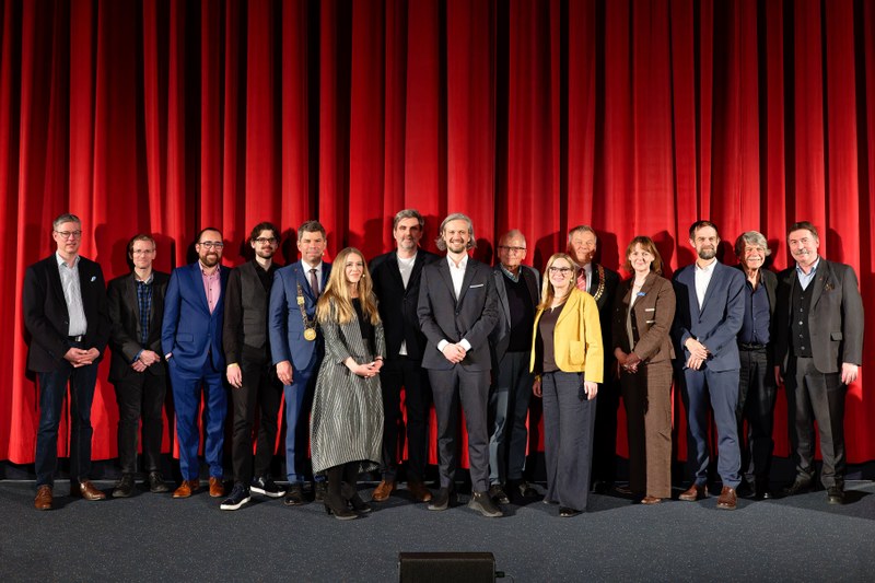 Gruppenbild vor Kinoleinwand bei der Verleihung des Marburger Kamerapreises 2024