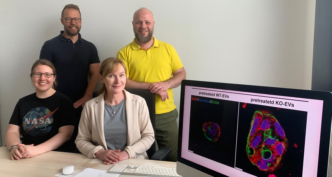 Gruppenfoto Wissenschaftlerinnen und Wissenschaftler mit einem Monitor