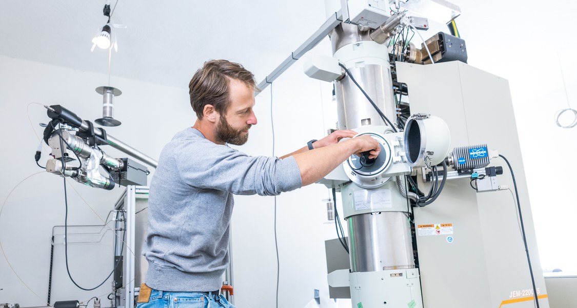 Foto eines Mitarbeiters an einem Elektronenmikroskop