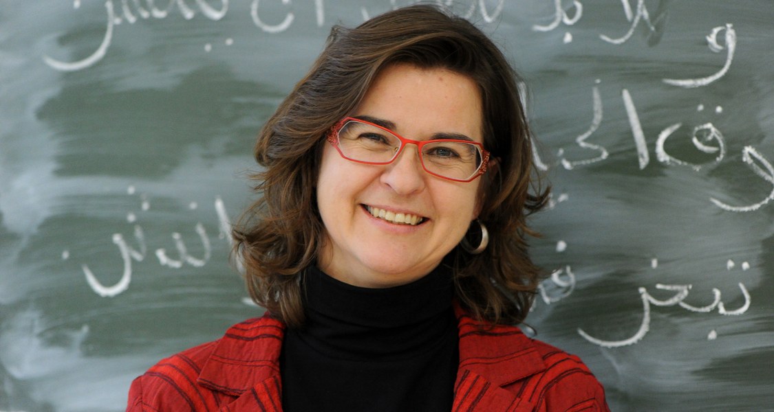 Porträtfoto Professorin von einer Tafel mit arabischen Schriftzeichen