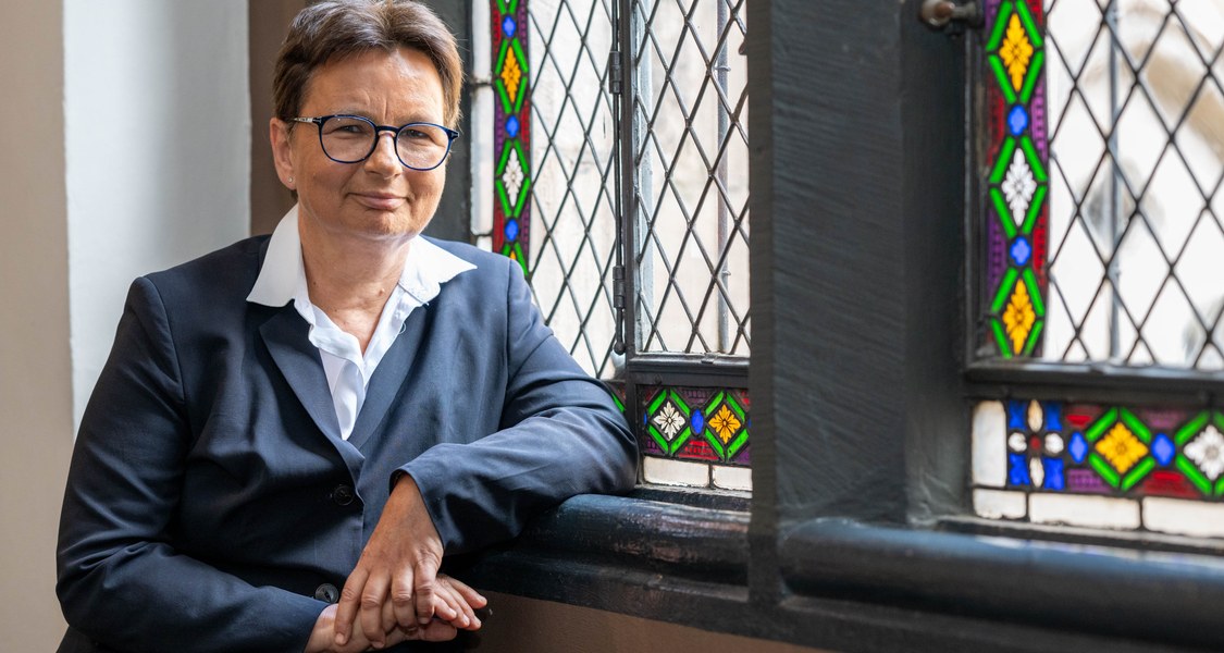 Porträtfoto Angela Standhartinger vor Buntglasfenstern in der Alten Universität