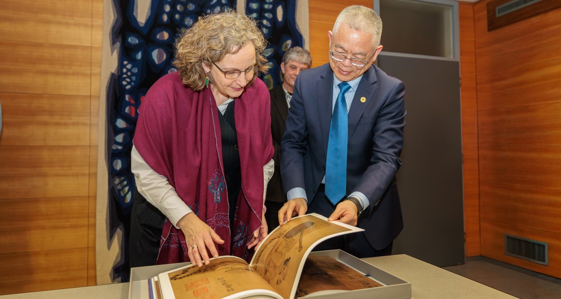 Blättern im Gastgeschenk: Vizepräsidentin der Uni Marburg, Prof. Dr. Evelyn Korn und ihr Besuch Prof. Dr. Qiang Fu, stellvertretender Vorsitzender des Universitätsrats der Zhejiang Universität (ZJU) aus Hangzhou, China.
