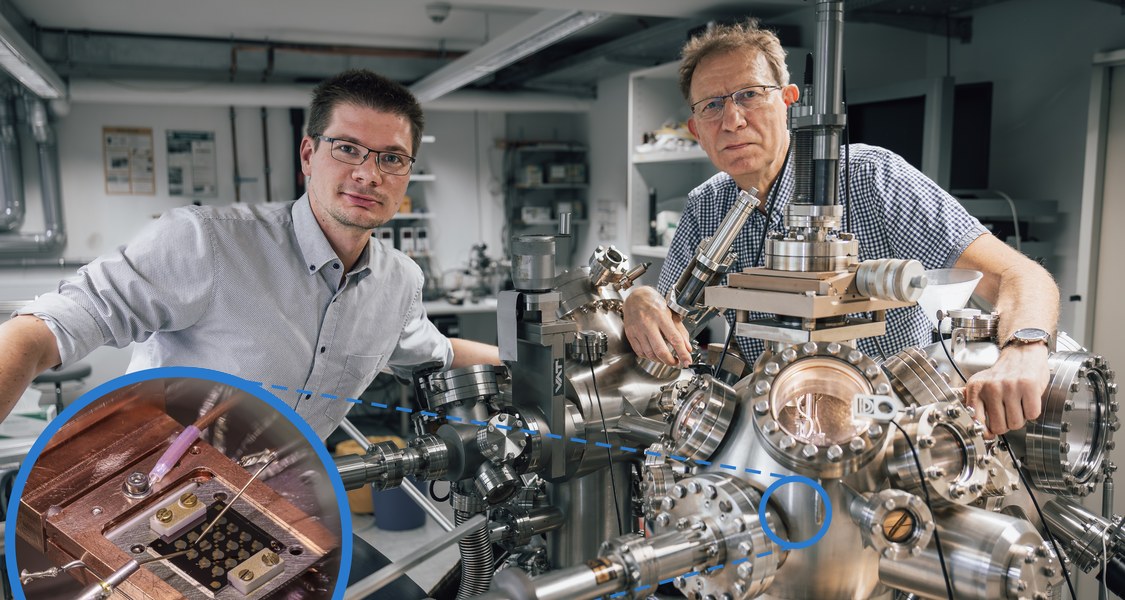zwei Physiker hinter physikalischen Apparaturen