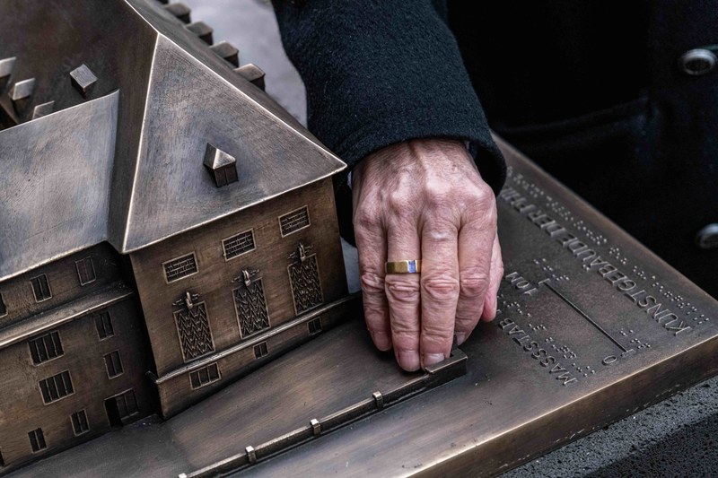 Eine Hand erspürt das Tastmodell des Kunstgebäudes.