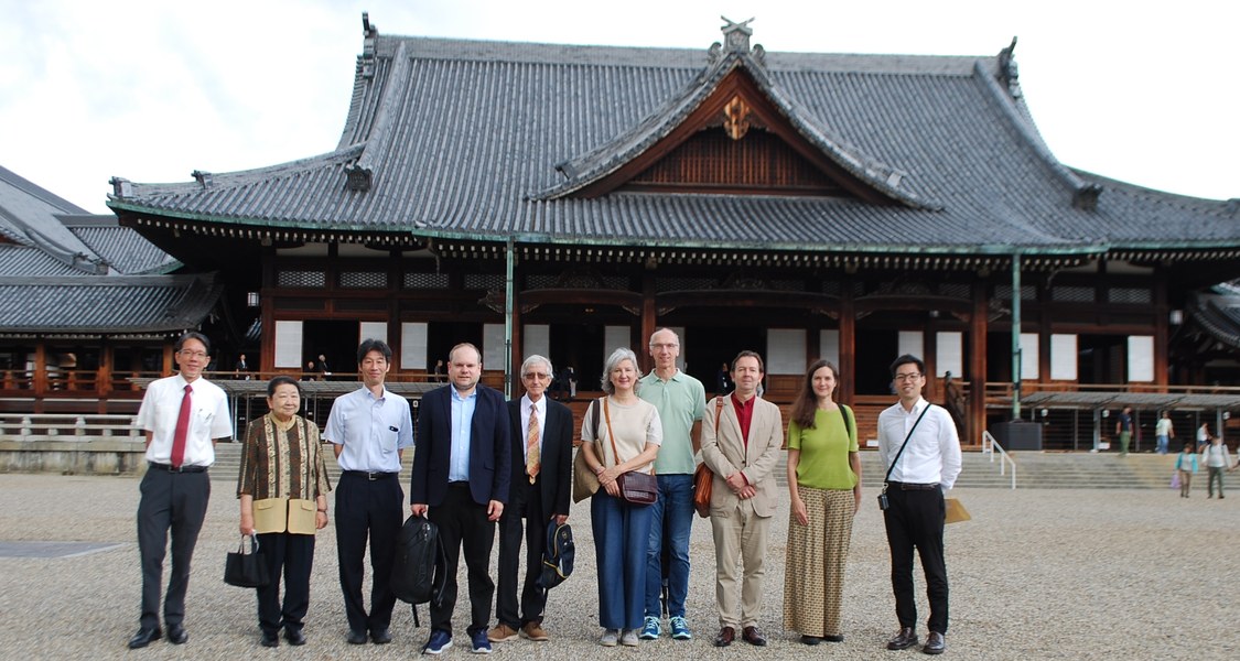 eine Menschengruppe vor japanischem Gebäude