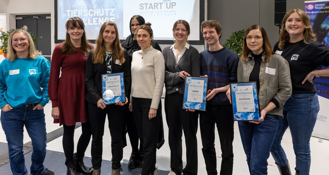 Eine Menschengruppe lacht in die Kamera