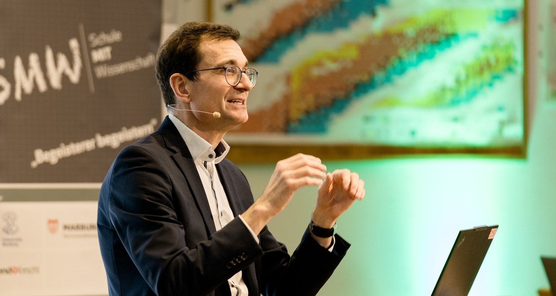 ein Mensch gestikuliert vor Publikum