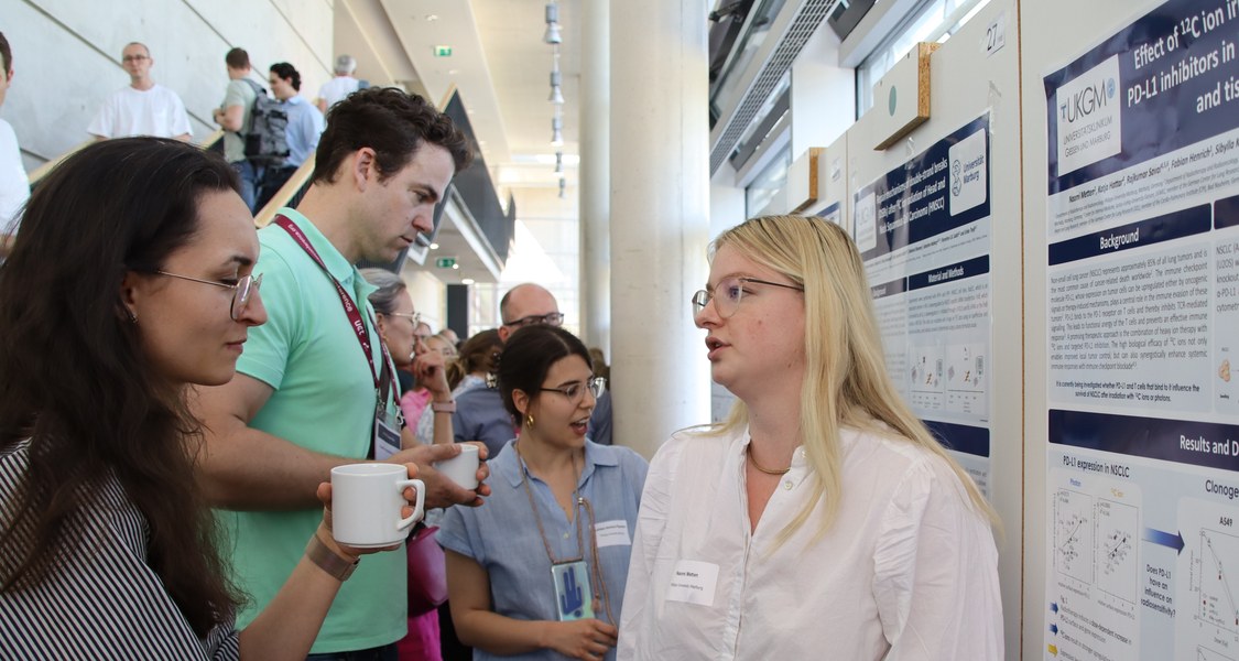 Forschende diskutieren wissenschaftliche Erkenntnisse am Poster.