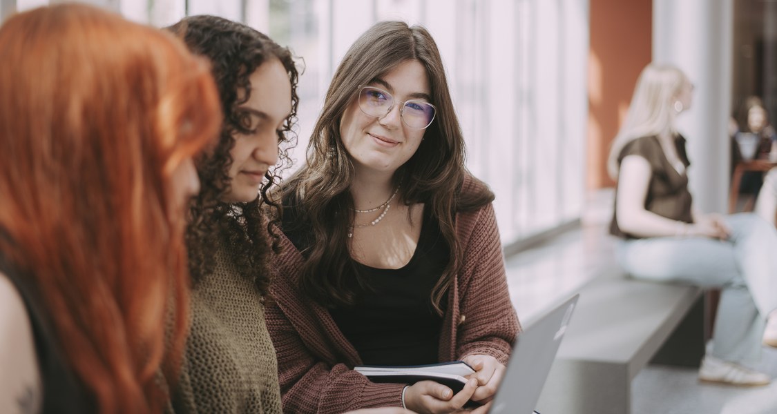 Studierende schauen gemeinsam auf einen Laptop