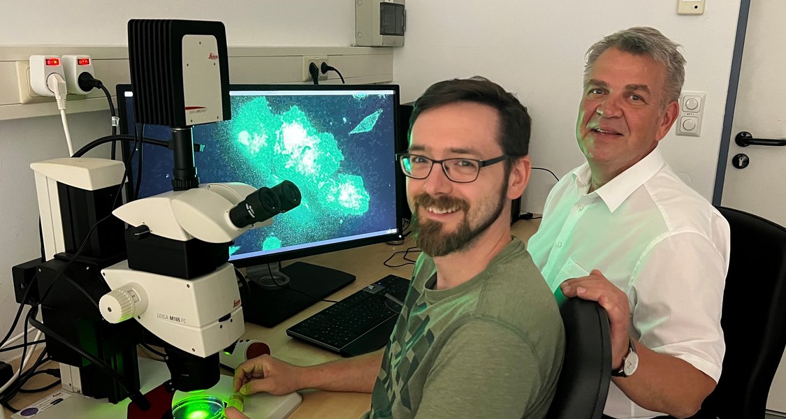 Darius Molitor und Sven Bogdan vor dem Fluoreszenz-Mikroskop.