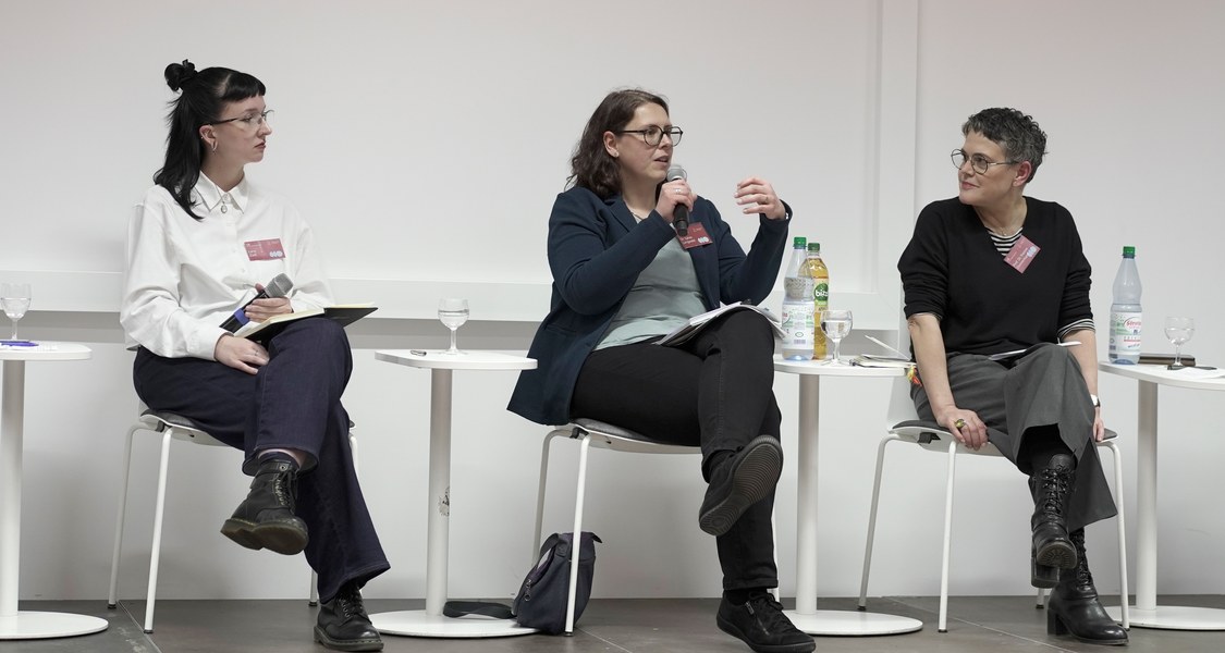 drei Menschen auf dem Podium