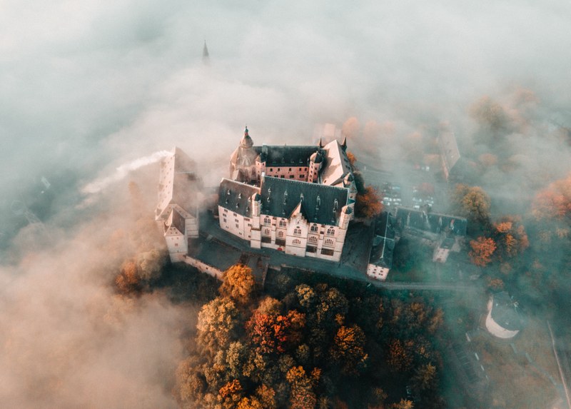 Luftaufnahme des Marburger Schlosses im Nebel