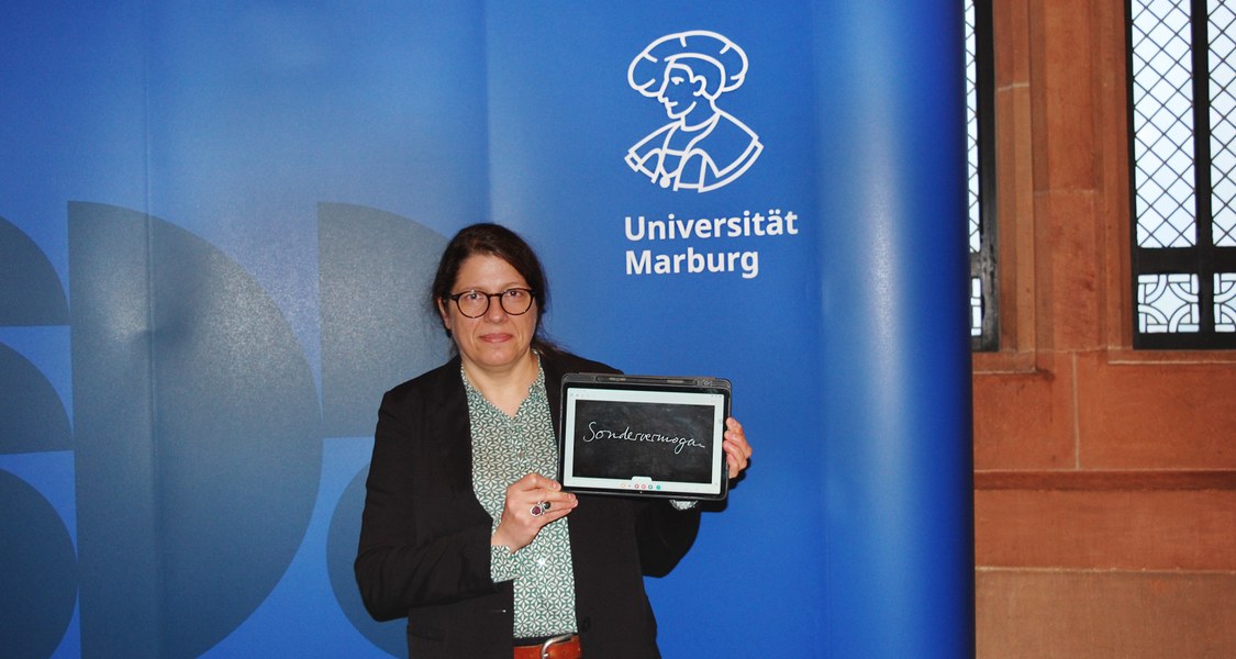 Person zeigt auf dem Tablett-Computer das Wort "Sondervermögen"