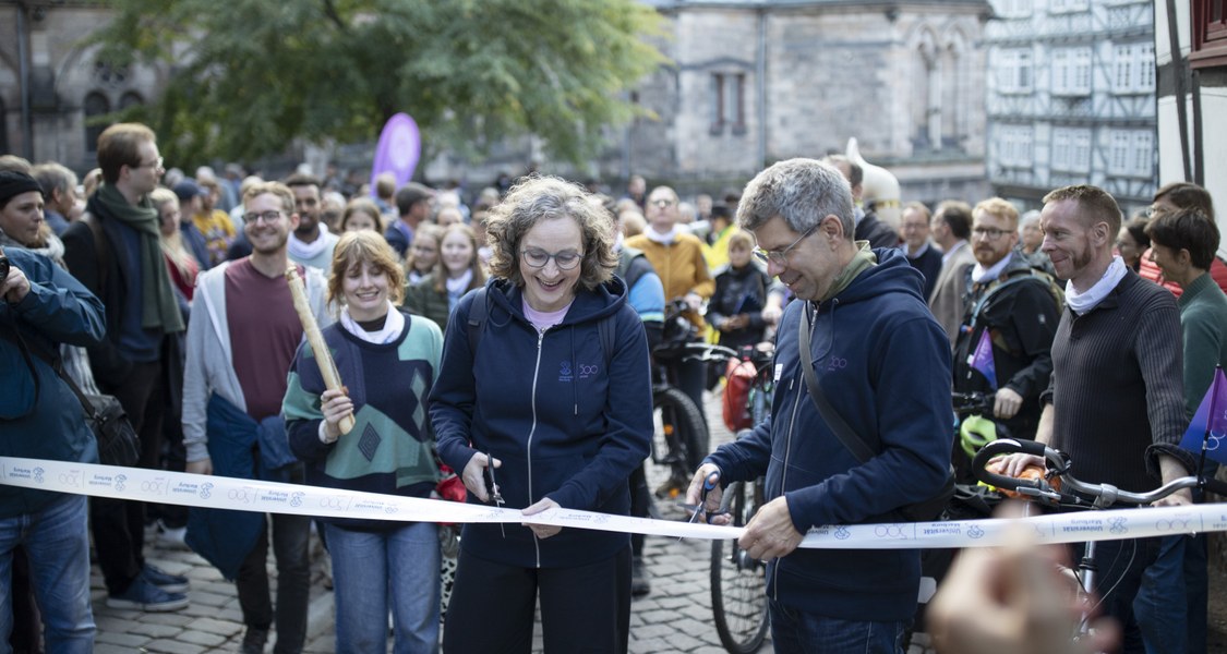 Uni-Präsident Prof. Dr. Thomas Nauss und Vizepräsidentin Prof. Dr. Evelyn Korn zerschneiden das Band an der Alten Universität als Startsignal für den Festzug zum Landgrafenschloss. Zuvor hatte die Universitätsgemeinde die Fahrradstaffel aus Homberg (Efze) empfangen. (Bilder-Galerie folgt)