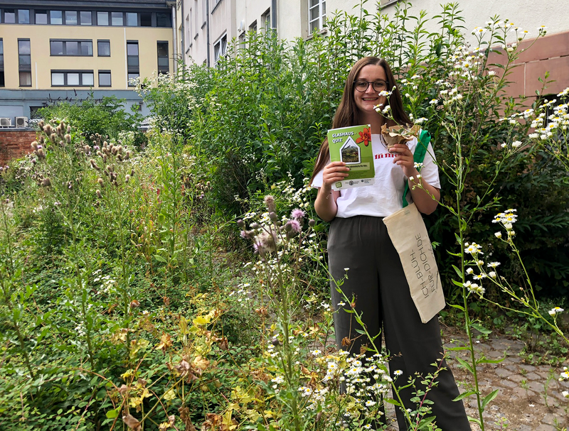 Das Foto zeigt die studentische Hilfskraft Chiara Burgard bei der Auslosung des Glashaus-Quiz.