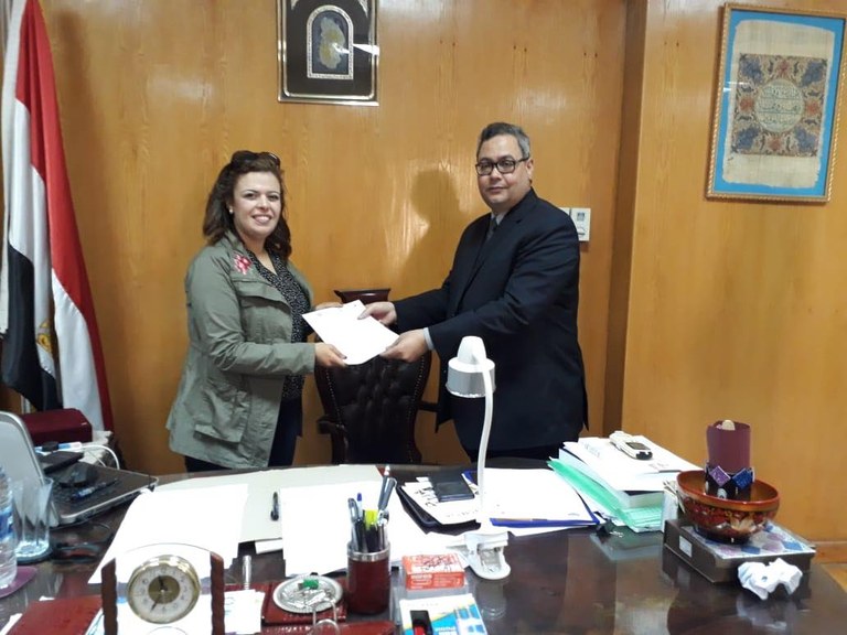 Hala Ghoname receiving the Memorandum of Understanding between the Department of Islamic Studies and the Faculty of Archaeology from Dr. Atef Mansour the Dean of the Faculty of Archaeology at Fayoum University, and the Chairman of the German-Egyptian Islamic Numismatics Center.