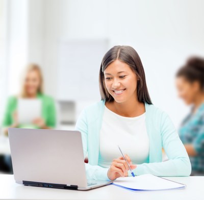 Studentin vor Laptop lächelnd