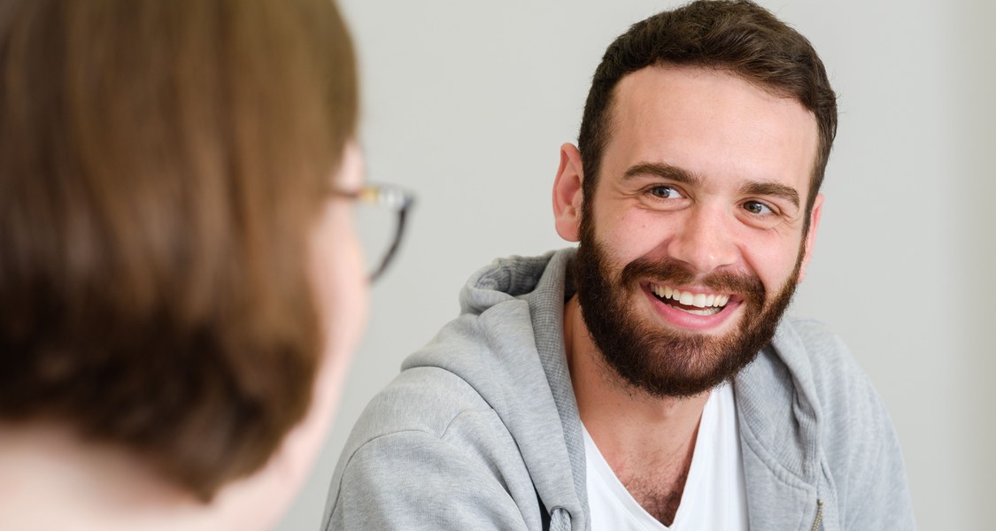 Studierender lachend im Gespräch