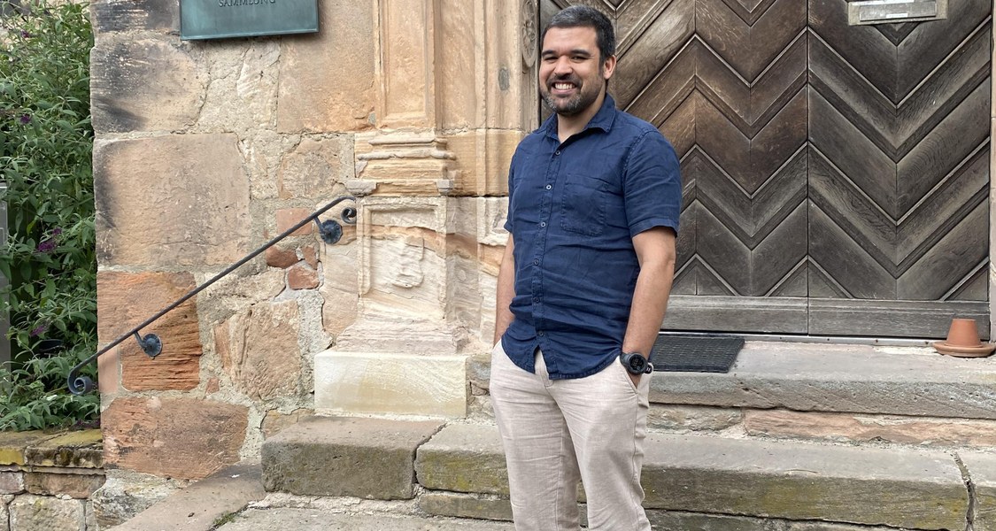 Nurman Nowak vor dem Eingangsportal der Religionswissenschaft