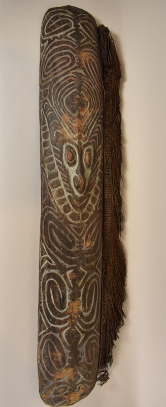 Langes Schild aus Holz geschnitzt mit weißen und roten Kalkfarben bemalt, Kokosnussfaser geflochten, Rattan.
