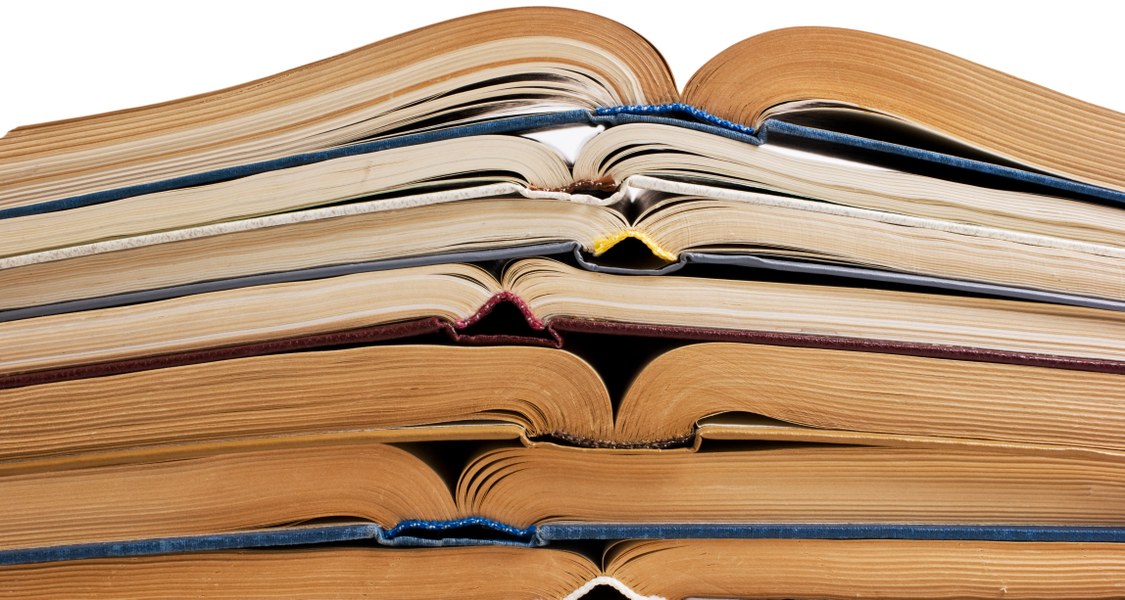 Stapel aus aufgeklappten Büchern