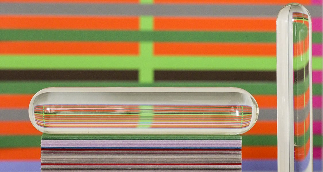 Arbeitssituation am Atelierplatz von Wenjie Dong. Geschnittenes, gestapeltes, buntes Papier, gebrochen durch Plexiglas- und Glasformen.