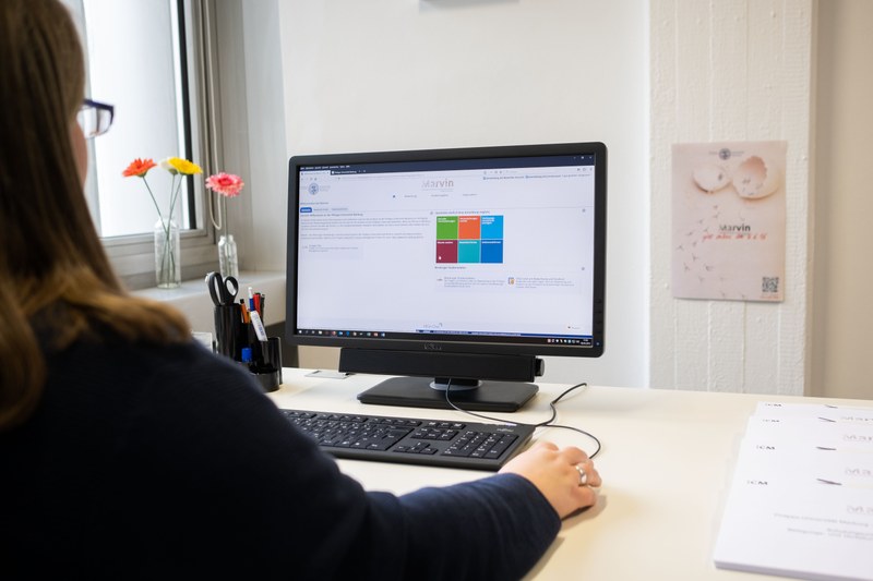 Eine junge Frau sitzt am PC und bearbeitet ihre digitale Bewerbung über MARVIN, das Marburger Verwaltungs- und Informationssystem der Philipps-Universität Marburg.