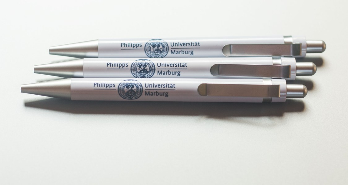 Drei Kugelschreiber mit Universitäts-Logo