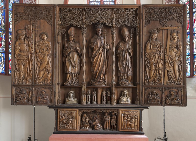 Holzsichtiges Triptychon mit Heiligendarstellungen.