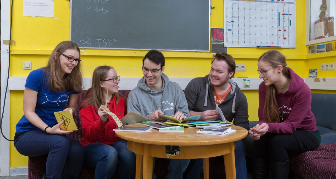 Studierende sitzen in einem Fachschaftsraum zusammen.