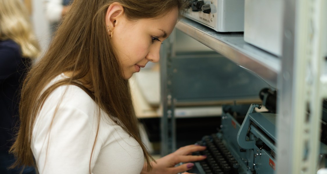 Studentin tippt auf einer Schreibmaschine