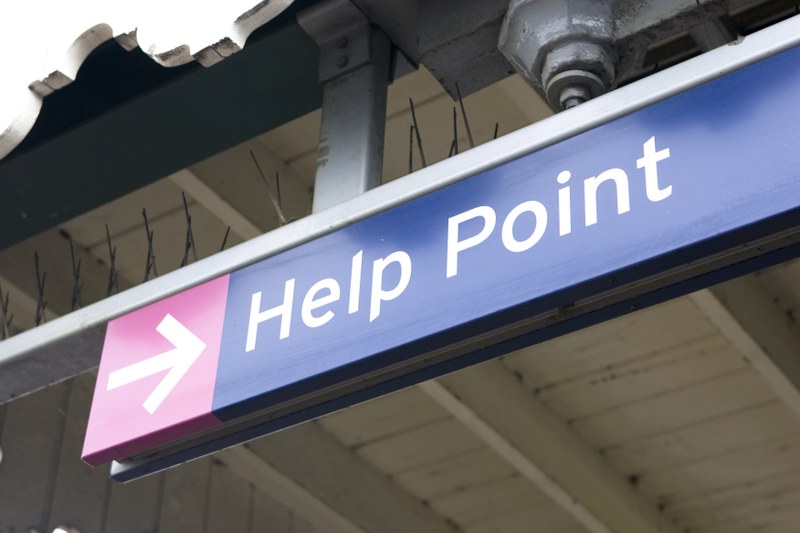 Wegweiser zu einem "Help Point", womöglich an einem Bahnhof.